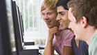 Three young men using the computer lab