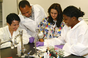 MDC’s Rosa Castro, an assistant professor of clinical laboratory technology (center, in multi-colored scrubs) works with Maria Rabello (the students’ tutor and translator); and student biologists from Mozambique, Martins Muloiua and Isabel Pinto.