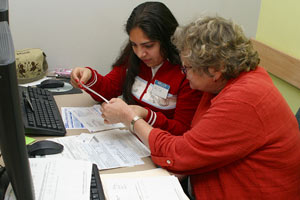 Volunteer helping a lady to file her taxes