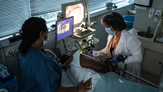 Endoscopic technician doing a test in front of a monitor