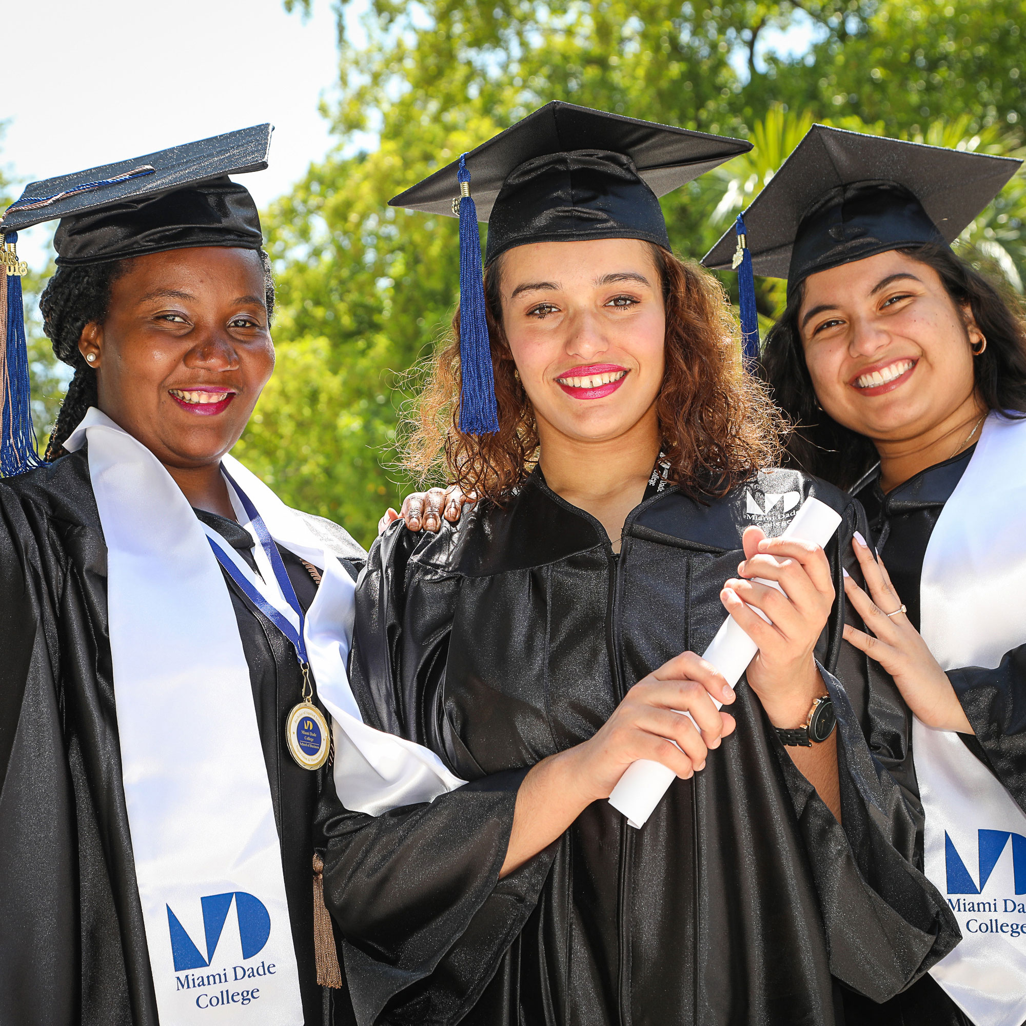 student graduating and standing with their diplomas