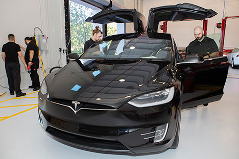 students fixing a tesla automobile