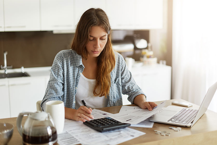 Woman at home working on her budget Worksheet