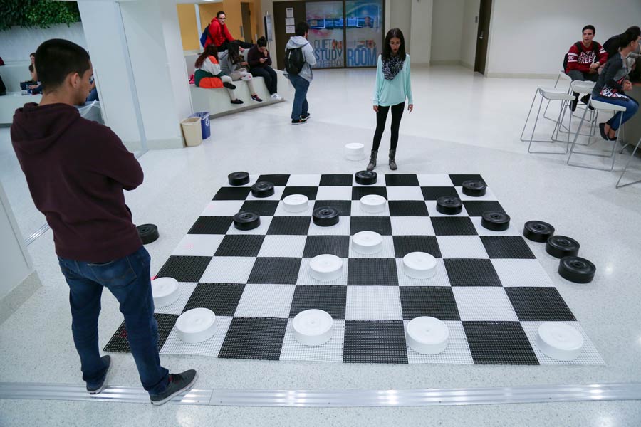 MDC Students playing checkers on the floor at Hialeah Campus