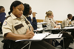 School of Justice student in klaslokaal, aantekeningen makend.