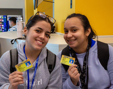 Two MDC students showing their student ID