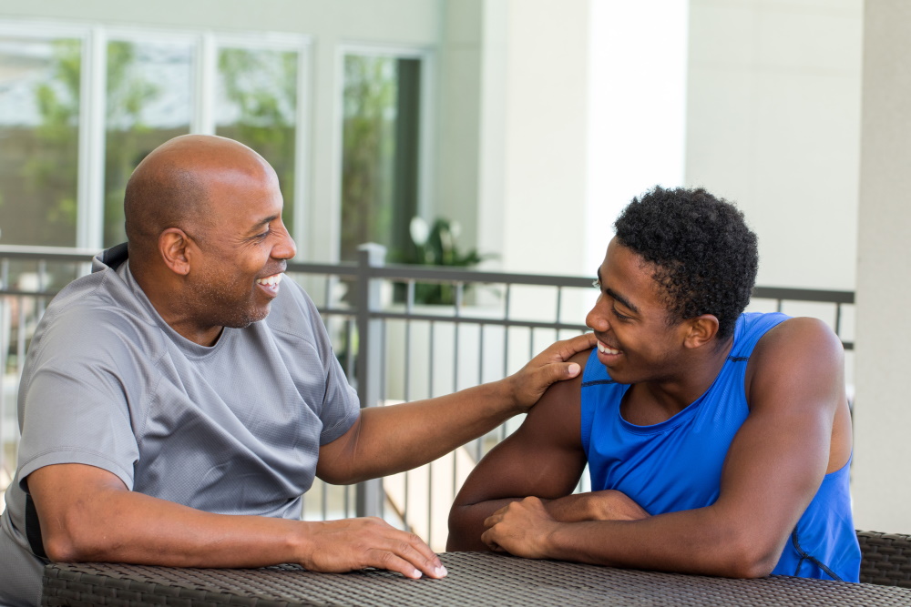 Father and son talking while sitting at table