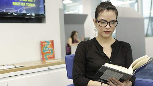 Female student studying language book in office