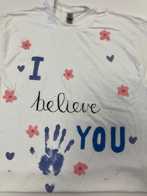 white tee shirt with the words 'I believe you' hand painted on it