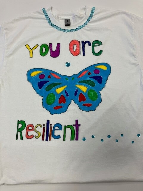 white tee shirt with the words 'you are resilient' hand painted on it