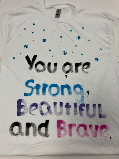 white tee shirt with the words 'you are strong, beautiful, and brave' hand painted on it